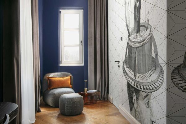 Chic and relaxing corner: Superior double room 'Memento' at Almayer Art & Heritage Hotel's annexe building, featuring a cosy armchair and pouffe.