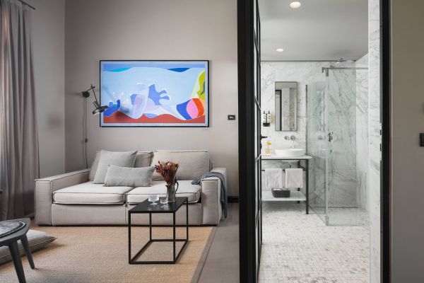 Comfortable living area and elegant marble bathroom in Deluxe mezzanine double room 'Tramontana' at Almayer Art & Heritage Hotel