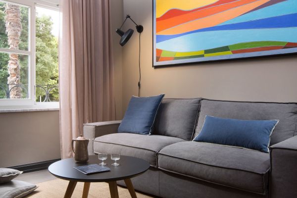 Stylish living area in Deluxe mezzanine double room 'Maistral' at Almayer Art & Heritage Hotel, with a pull-out queen-size sofa bed and serene garden view