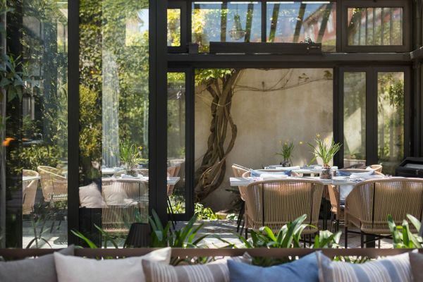 Indulge in the luminous ambience of Corte Restaurant, nestled in Almayer's Orangerie, embraced by a verdant secret garden with Mediterranean plants