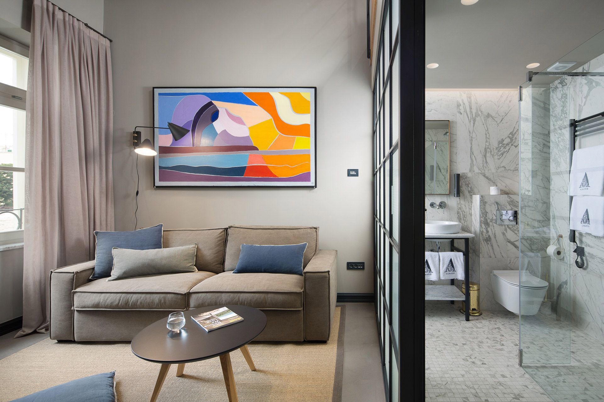 Side view of the Almayer hotel’s deluxe mezzanine double room and its living area and bathroom